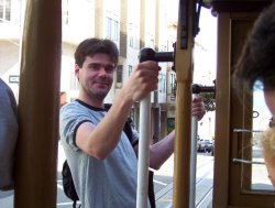 Mark hangs precariously off he cable car, blissfully unaware that a bloody great station wagon is heading the other way...